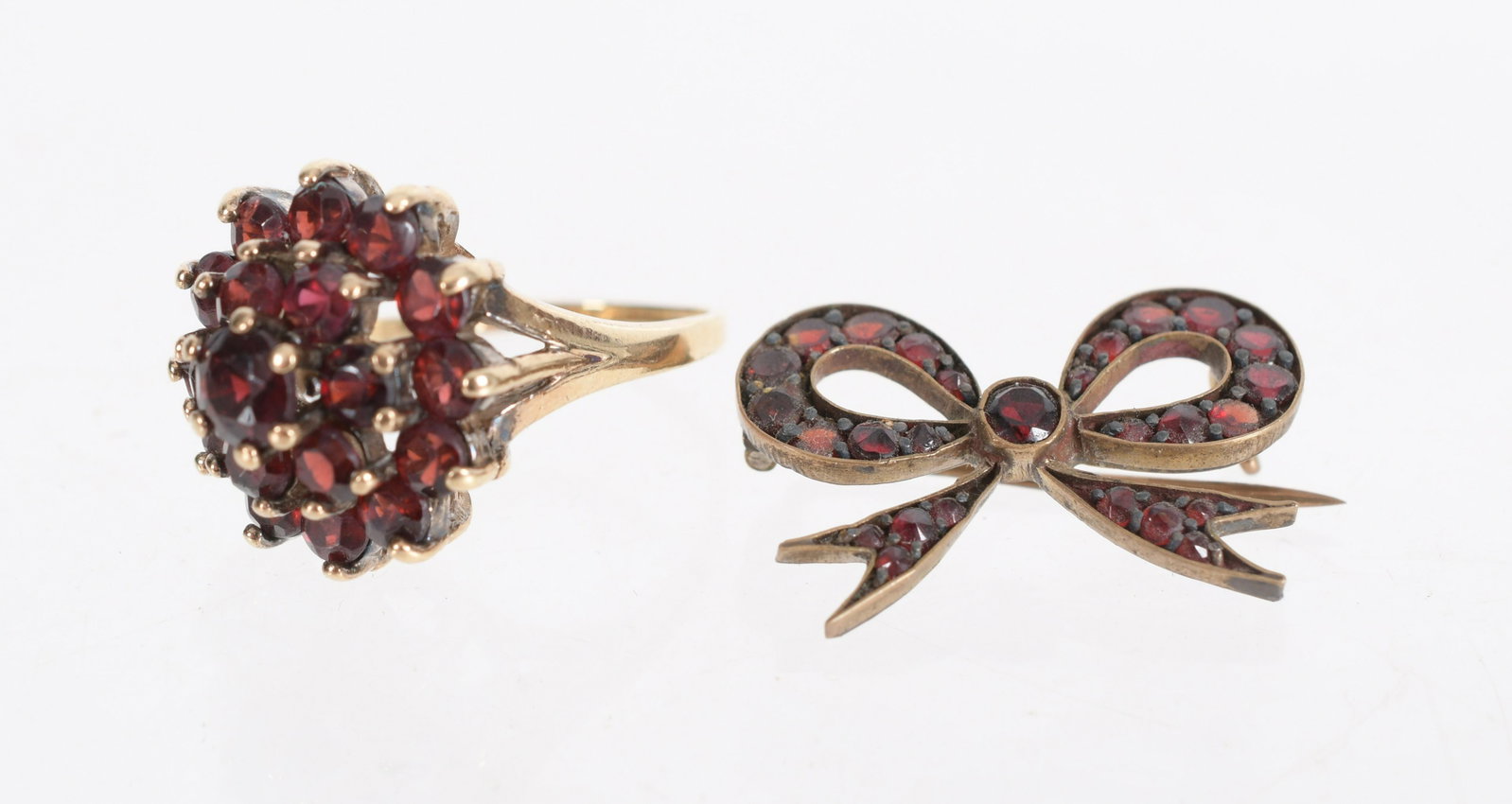 Two Pieces of Gold and Garnet Jewelry: A 14k yellow gold cocktail ring set with tiered garnets and a bow form garnet and gold filled pin. Dimension:The ring is size 6, the pin is 1" x 1/2". The approximate gross weight of the ring is 5.0 d