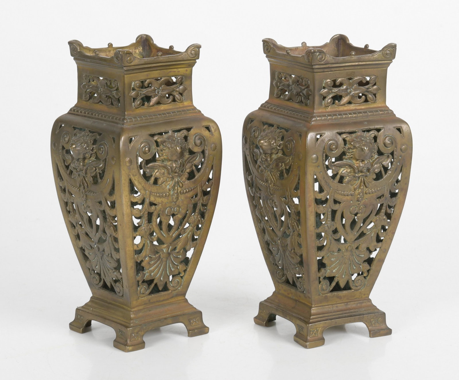 Pair Renaissance Revival Pierced Brass Vases: A pair of Renaissance Revival pierced brass vases, late 19th century, each decorated with foliate scrolls and winged putti masks to all four sides, each indistinctly stamped to the underside. Dimensio