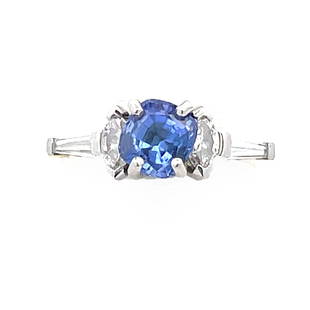 Platinum, 18K Diamond and Tanzanite Ring: A Platinum, 18K Diamond and Tanzanite Ring, with a cushion shape tanzanite in the center and marquise and tapered baguette shape diamonds on the side, Tanzanite: 7mm x 7.2mm Total Diamond Weight: