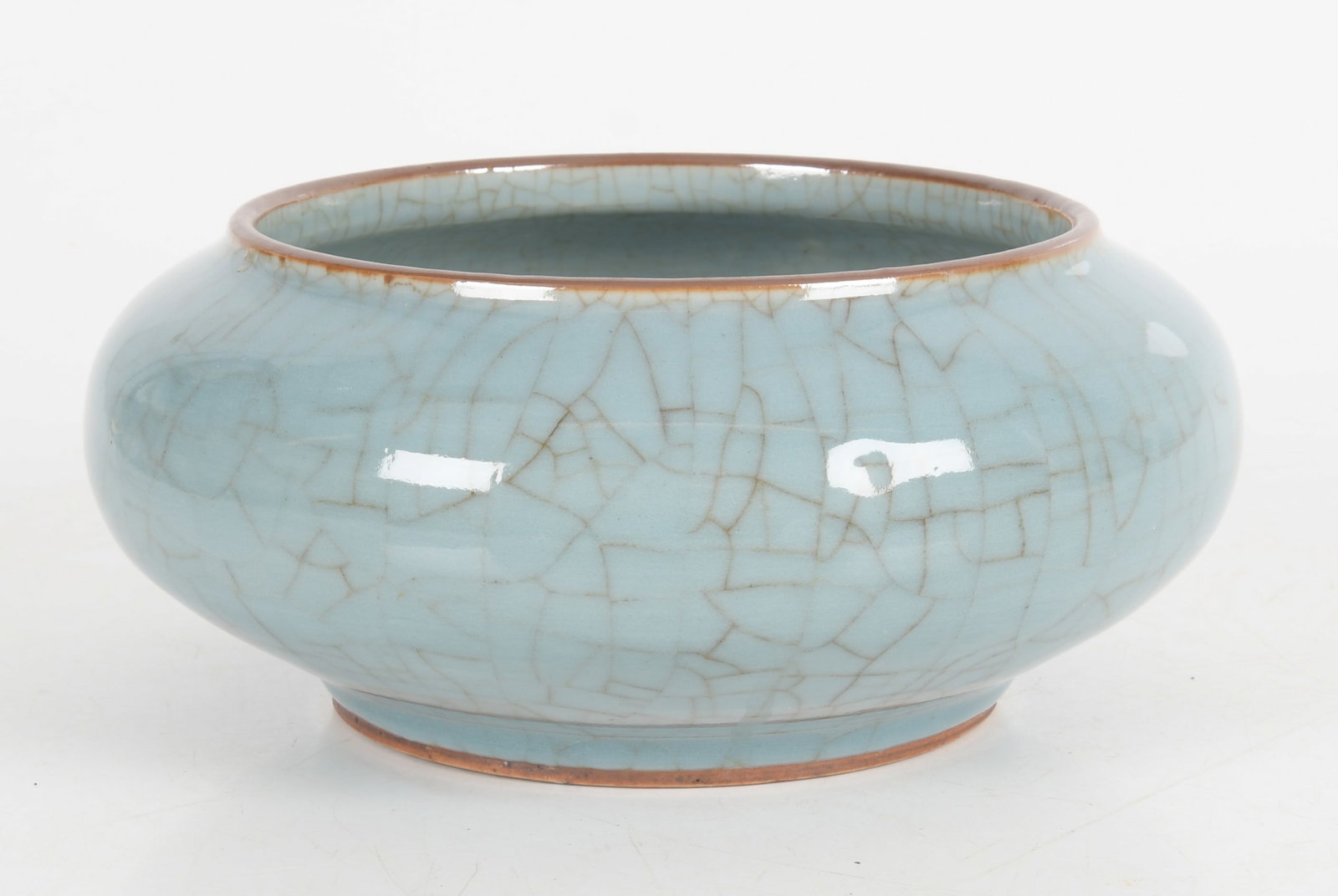 A Chinese Crackle Glaze Bowl: A celadon example with a copper glazes rim. 19th century or earlier. Dimensions: 10" in diameter, the height is 4 1/2". Provenance: Property from a