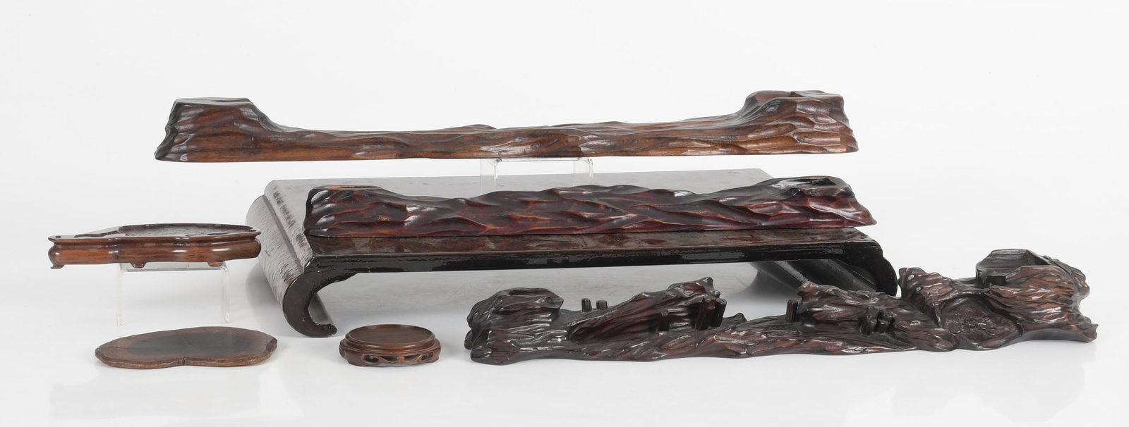 A Group of Japanese Wooden Stands: Three large chip carved examples, one small circular example with Ando label, two other small stands and a large rectangular example with scrolled feet and a lacquered surface. Dimensions: from