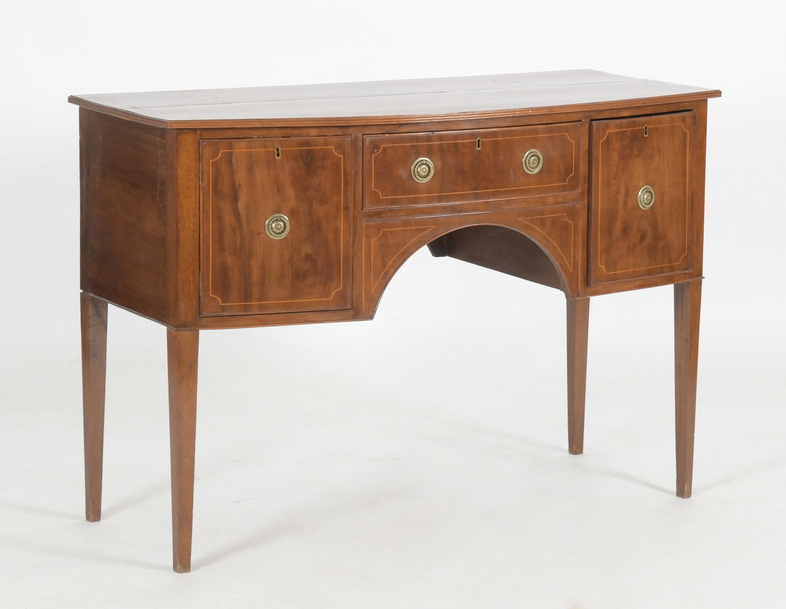 Federal Style Inlaid Mahogany Sideboard: A Federal Style Inlaid Mahogany Sideboard, Late 19th Century. The crossbanded rectangular top with bow front and reeded molded edge over a conforming case, fitted with a single drawer with cupboa