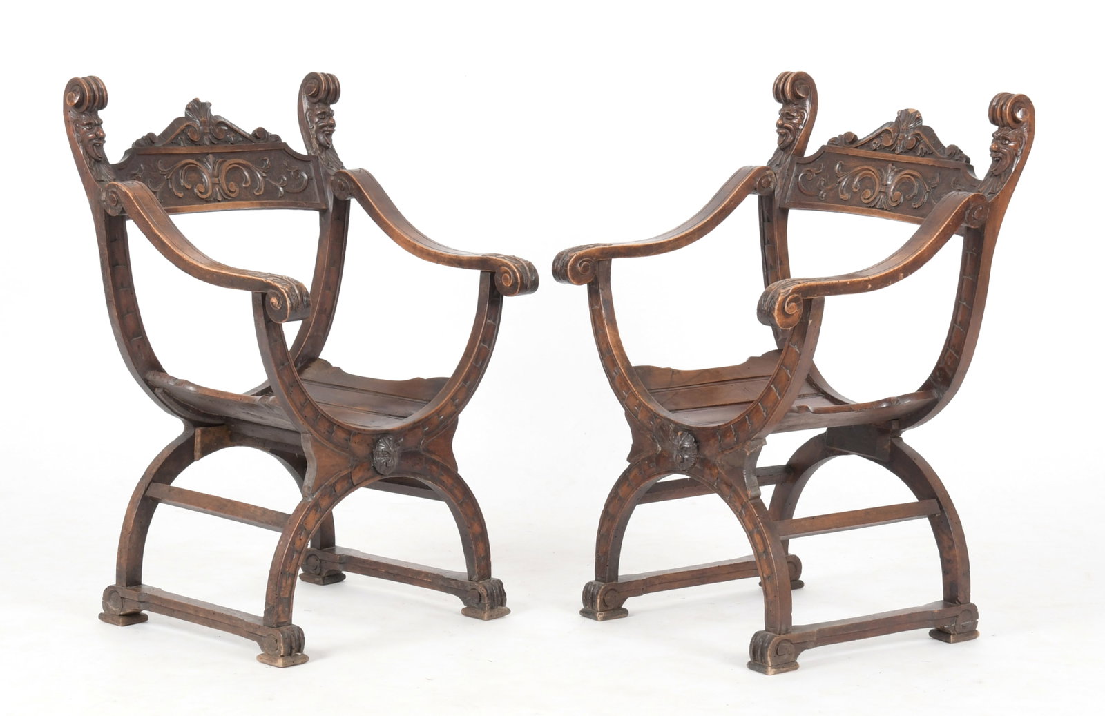 Pair of Renaissance Revival Carved Walnut Savonarola Chairs: A Pair of Renaissance Revival Carved Walnut Savonarola Chairs, Late 19th Century. Each carved with foliates, scrolls and grotesque masks. (2) Dimensions: Height 34 1/2in; width 22in; depth of sea
