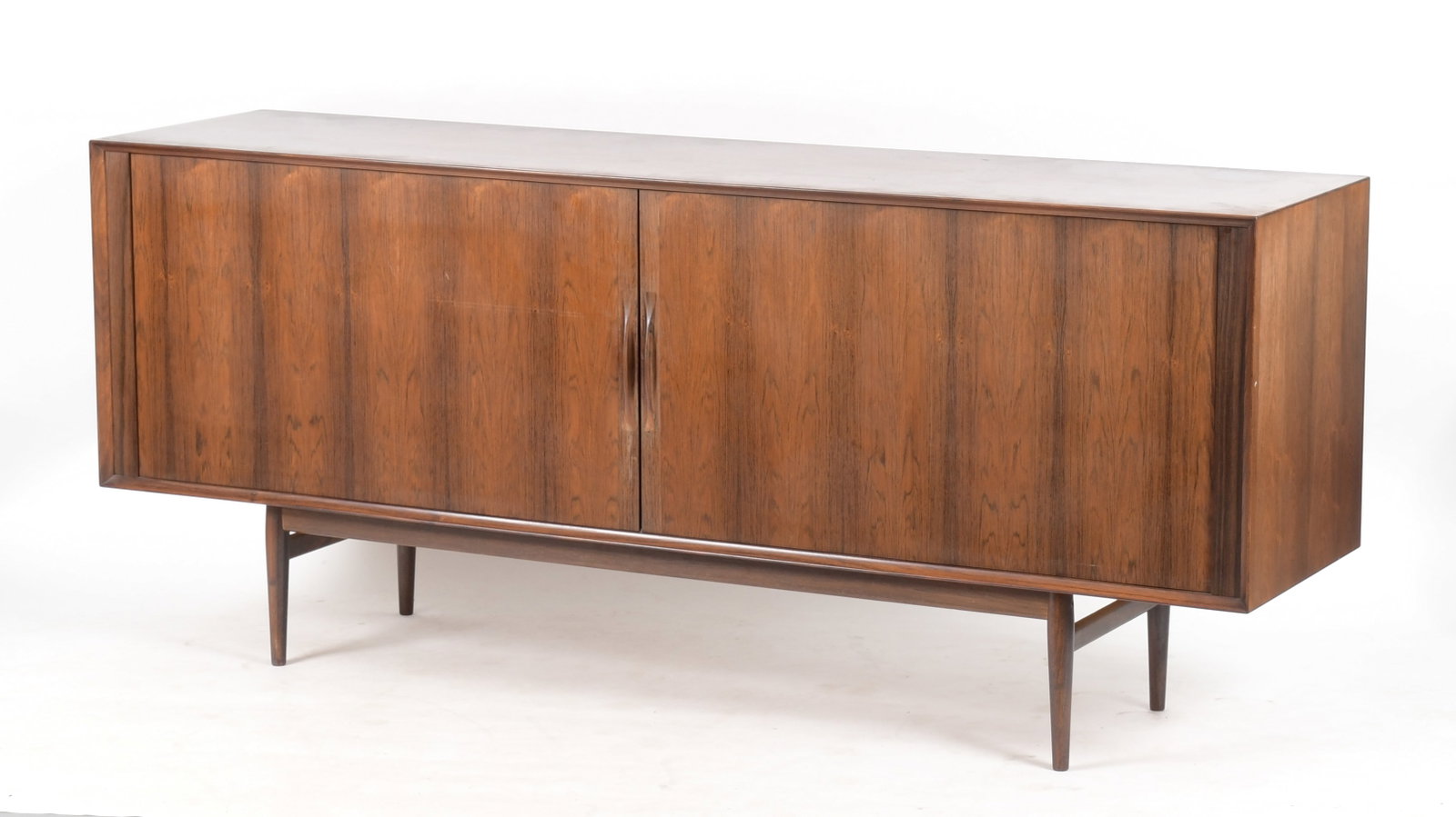 Danish Modern Rosewood and Teak Credenza, Mid 20th Century: A Danish Modern Rosewood and Teak Credenza, Mid 20th Century. Having a pair of tambour doors enclosing a teak interior fitted with adjustable shelves and drawers, raised on turned tapered legs. Dimens