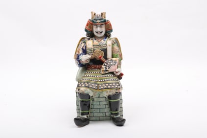 A Japanese Porcelain Kutani Figure of a Seated Samurai