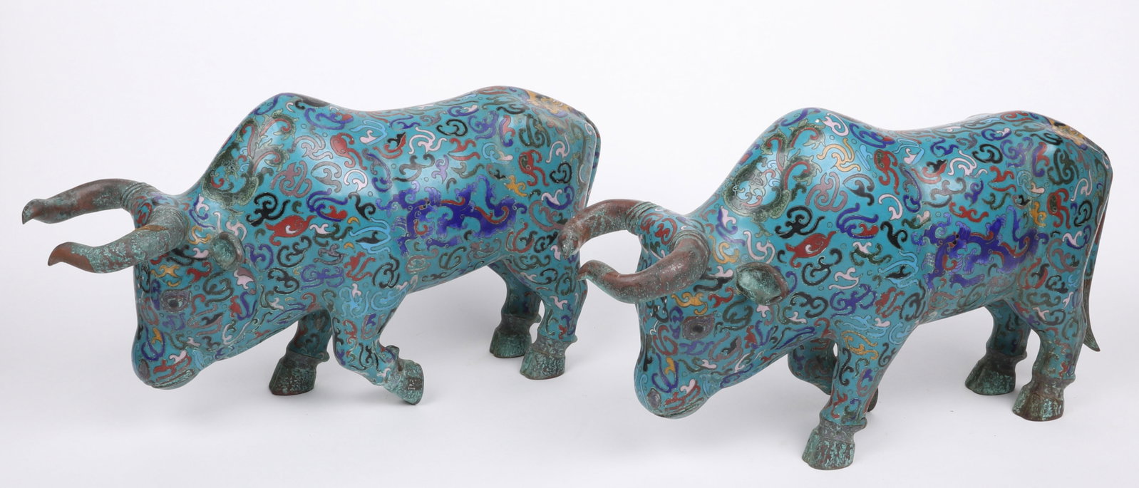 A Pair of Large Chinese Cloisonne Bulls: A Pair of Large Chinese Cloisonne Bulls 20th century, each with a blue ground and decoration that features dragons, masks and clouds. Dimensions: each is 20 1/2in x 8 1/2in and 12in tall.&