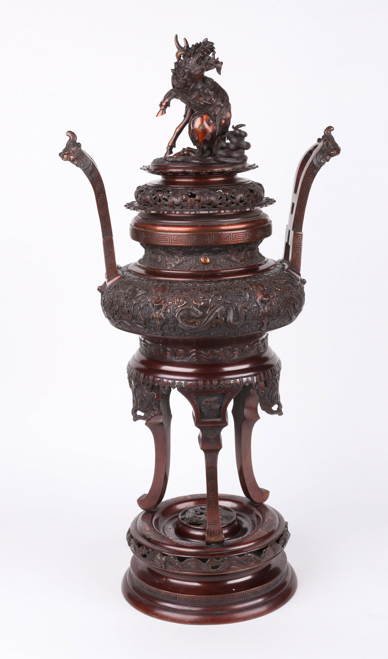 A Large Japanese Bronze Koro: A Large Japanese Bronze Koro Late 19th or early 20th century, the circular base below three out-sweeping legs, a dragon decorated body with large open handles, all below a Kirin finial. Unmarked