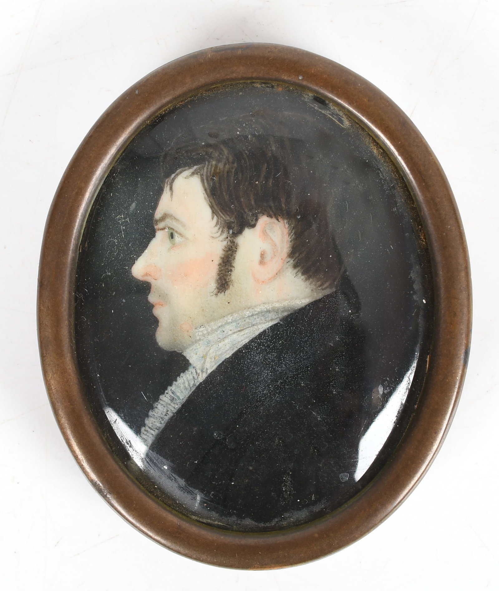 Portrait Miniature of a Gentleman, Early 19th Century: A Portrait Miniature of a Gentleman, Early 19th Century Watercolor, unsigned. Depicting a blue-eyed young man with brown hair in profile, attired in a black coat. Framed in a brass locket case. 