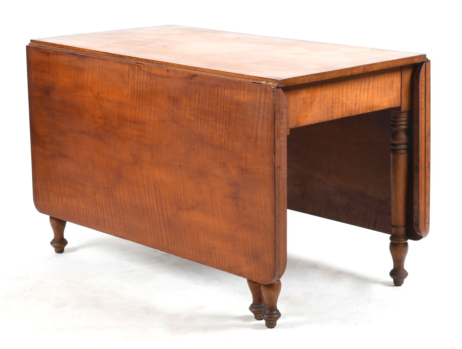 Sheraton Tiger Maple Drop-Leaf Dining Table, Second Quarter 19th Century: A Sheraton Tiger Maple Drop-Leaf Dining Table, Second Quarter 19th Century The rectangular top with drop-leaves having rounded corners, raised on turned tapered legs. Dimensions: Height 28in; wid