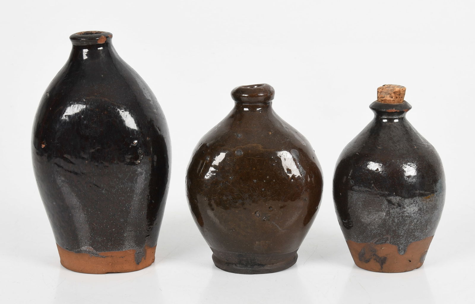 Three American Lead and Manganese Glazed Redware Flasks, First Half 19th Century: Three American Lead and Manganese Glazed Redware Flasks, First Half 19th Century Each lead and manganese glazed, ovoid form with flattened sides, unglazed foot. Comprising a 5in flask, purchased