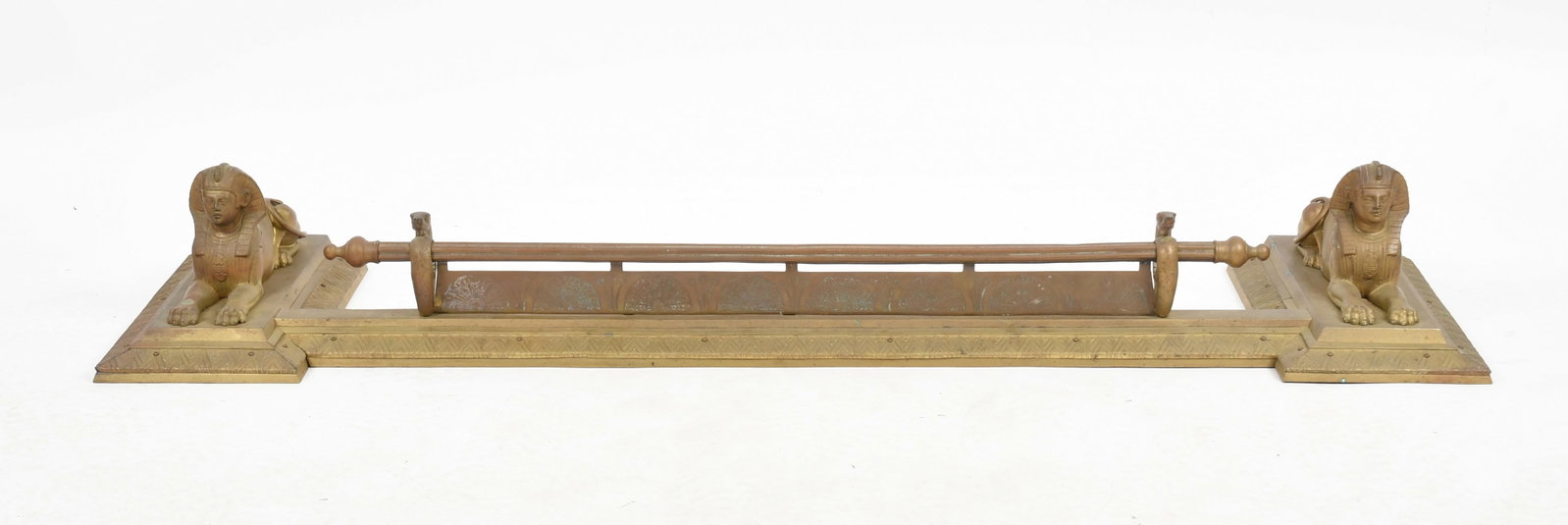An Egyptian Revival Brass Fire Fender, Late 19th Century: An Egyptian Revival Brass Fire Fender, Late 19th Century The reverse breakfront fender having serpent supports to the low horizontal guard rod, flanked by a recumbent Sphinx to either end. Dimensions: