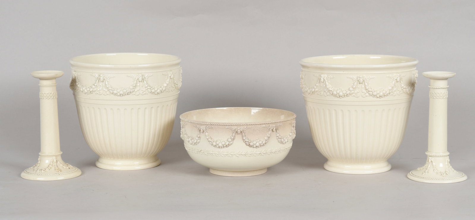 A Group of Wedgwood Queensware: A Group of Wedgwood Queensware 19th and early 20th centuries, comprising: a pair of fluted jardinieres with rams head and festoon decoration, a serving bowl with similar decoration and