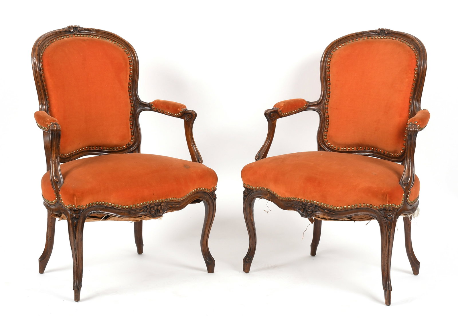 A Pair of Louis XV Carved Walnut Fauteuils, Mid 18th Century: A Pair of Louis XV Carved Walnut Fauteuils, Mid 18th Century With flowerhead carving on crest and apron, padded backs and seats, on cabriole legs Dimensions: 24 in. wide, 19 1
