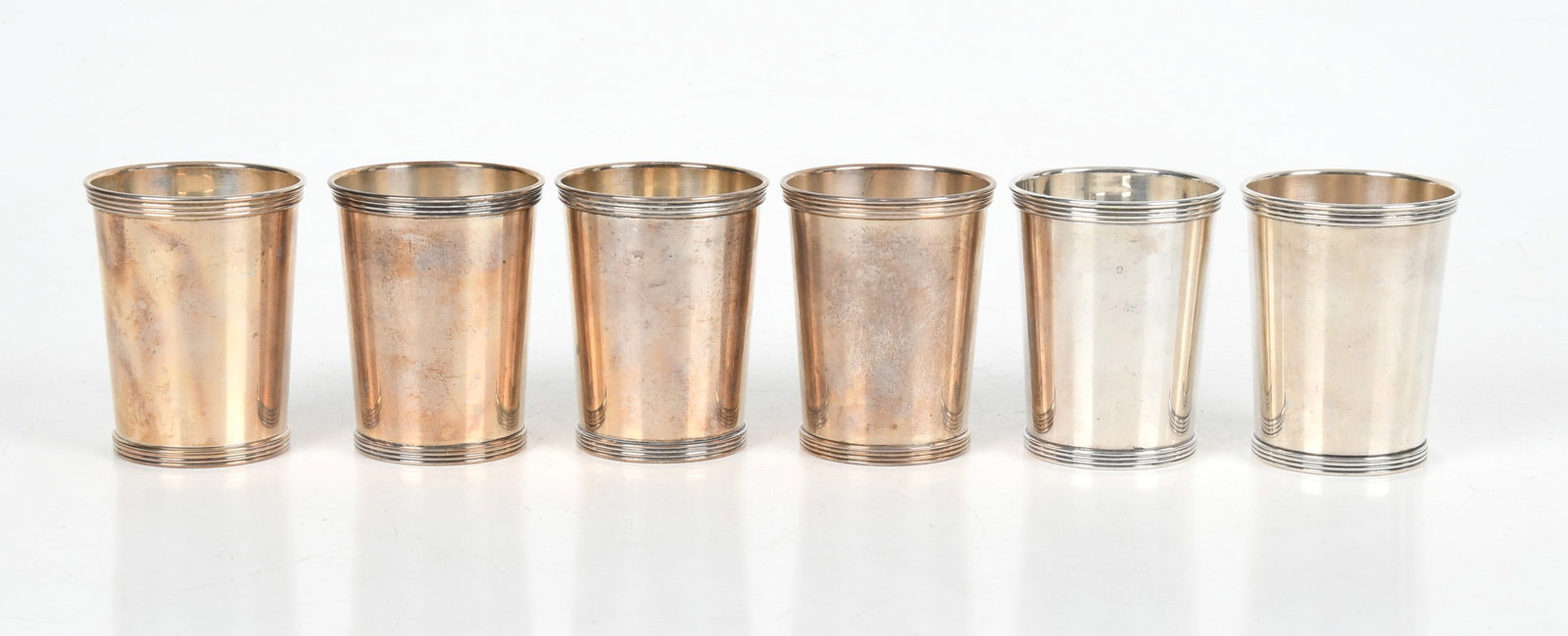 A Set of Six Sterling Silver Julep Cups: A Set of Six Sterling Silver Julep Cups Each with tapered sides and a reeded top rim, by International. Dimensions: each is 3in diameter and 4in tall, the total approximate weight is 23.5