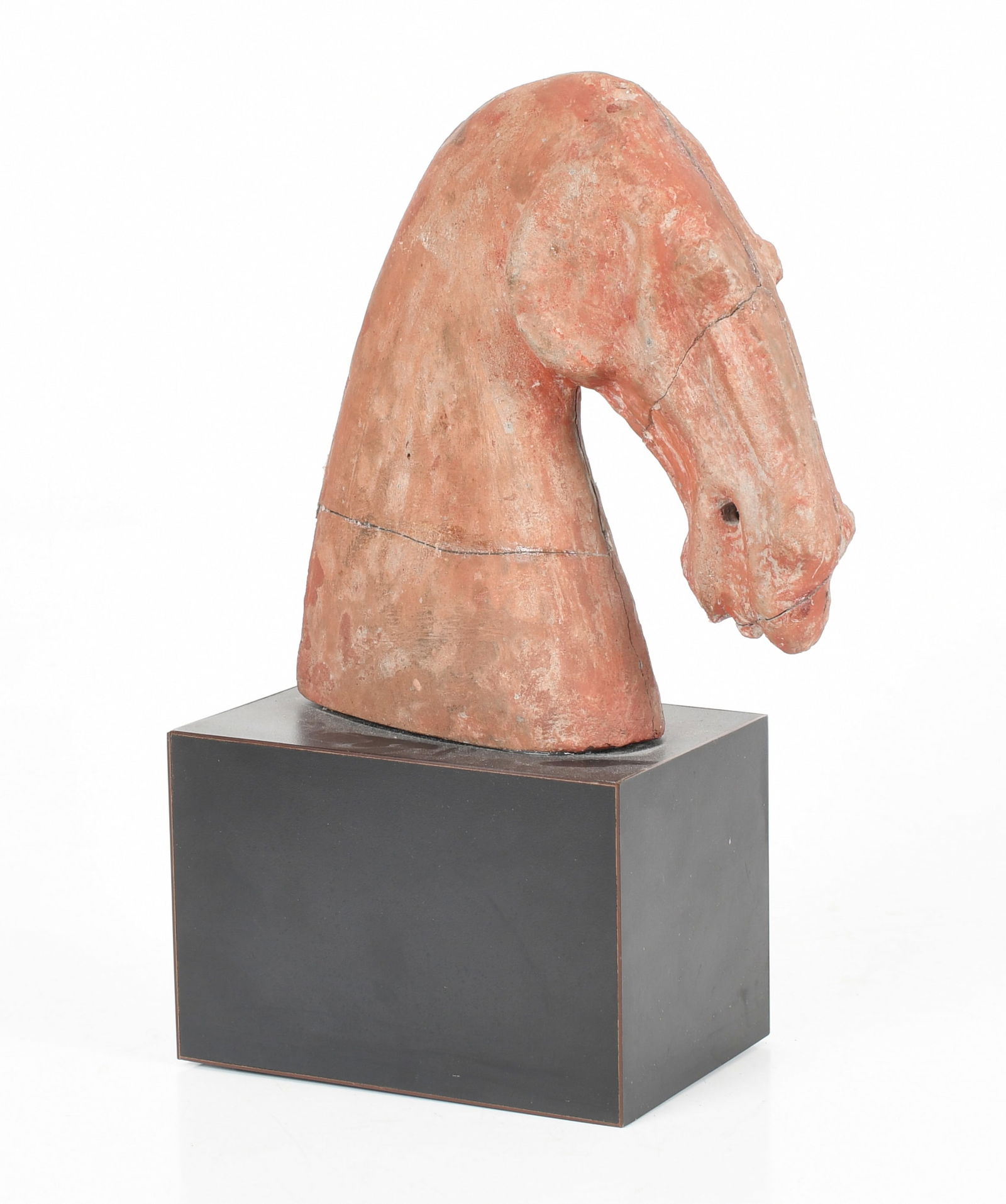 A Chinese Han-Style Terracotta Horse Head Fragment: A Chinese Han-Style Terracotta Horse Head Fragment With a red wash; raised on a composite base. Dimensions: 8 in. high, 12 1/2 in. high, overall Provenance: Hong Kong Art Craft