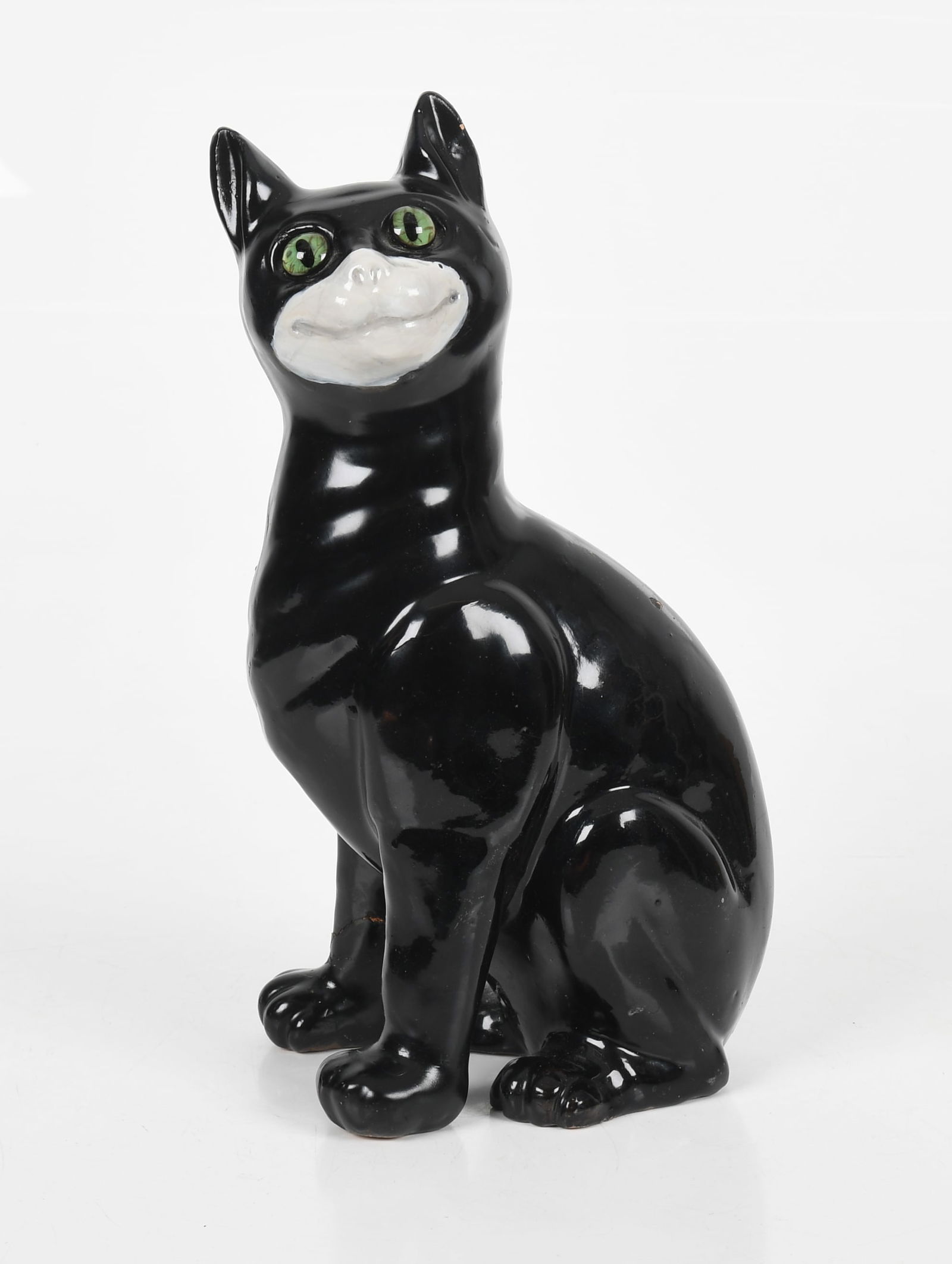 An Emile Galle Faience Cat, c. 1900: An Emile Galle Nancy Faience Cat, c. 1900 A French terracotta figure of a seated cat in black and white glaze with green glass eyes; signed on the underside of one paw "Galle