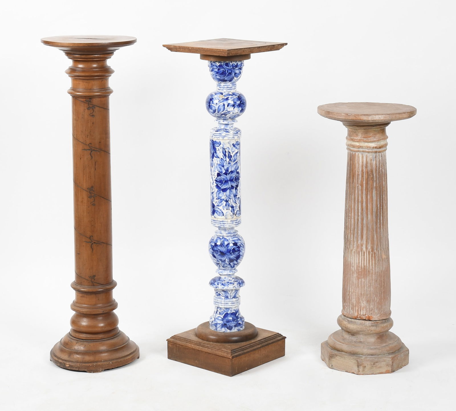 Three Pedestal Columns, Late 19th/ 20th Century: Three Pedestal Columns, Late 19th/ 20th Century Comprising: a terracotta fluted example; a mahogany and blue and white porcelain-mounted example; and an incised fruitwood example. Dime