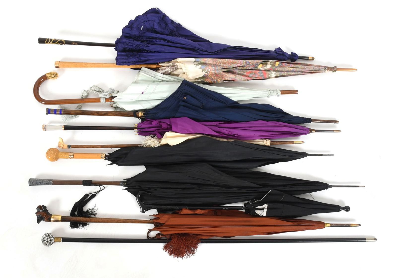 Ten Parasols/Umbrellas: Ten Parasols/Umbrellas Late 19th to first half of the 20th century, comprising: an example with an enameled sterling silver handle imitating a screw by J. Howell, Birmingham, an