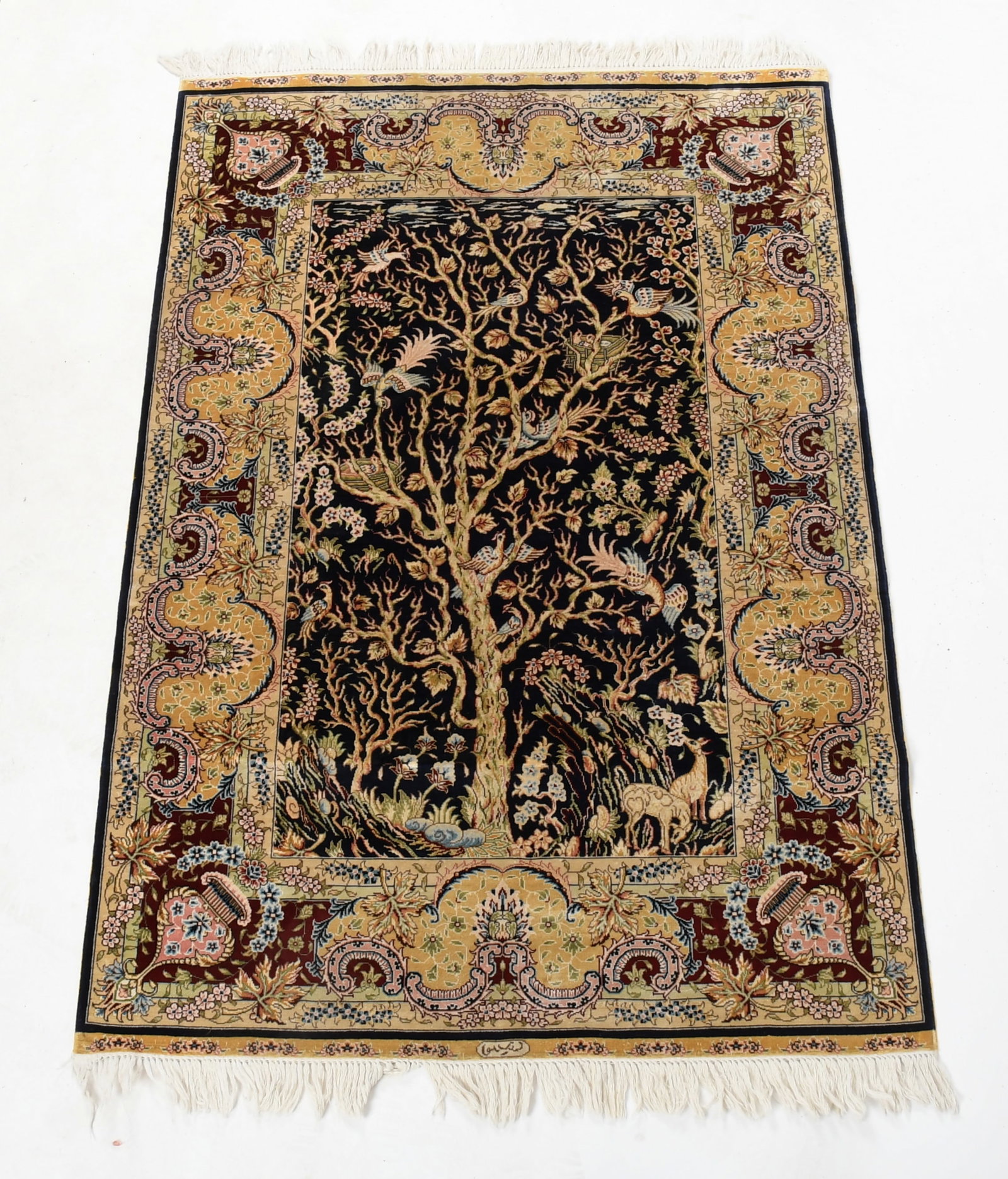 A Persian Style 'Tree of Life' Rug: A Persian Style 'Tree of Life' Rug 20th century, silk, the pictorial rug with a blue field, various animals, plants and decorative elements and a red border, signed at the lower