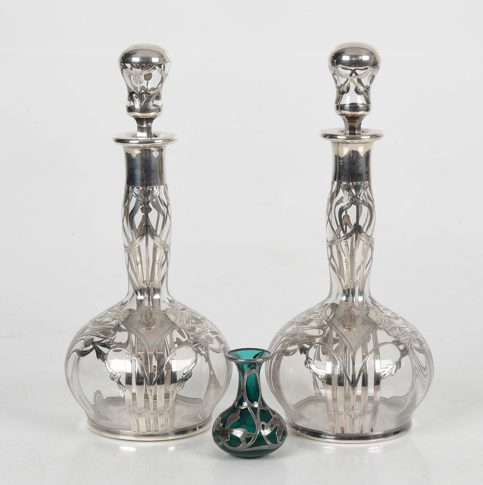 Three Pieces of Sterling Overlay Glass: Three Pieces of Sterling Overlay Glass Early 20th century, all marked for sterling silver mounting with floral decoration, comprising: a 2 1/2in diminutive green glass vase
