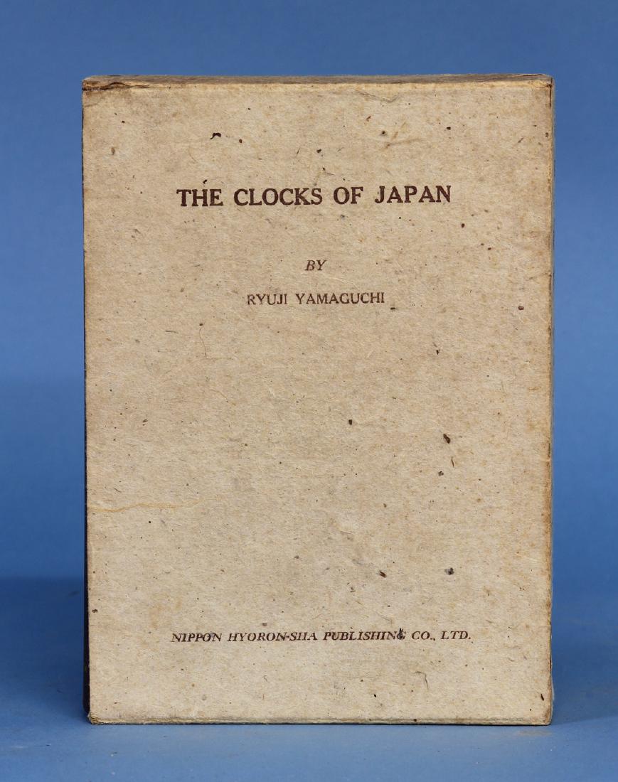 The Clocks of Japan by Ryuji Yamaguchi: Published in 1950 by Nippon Hyoron-sha Publishers Red cloth cover with gilt and colored characters and graphics. Original Cardboard protective sleeve. Contains French, English and Japanese text. Signe
