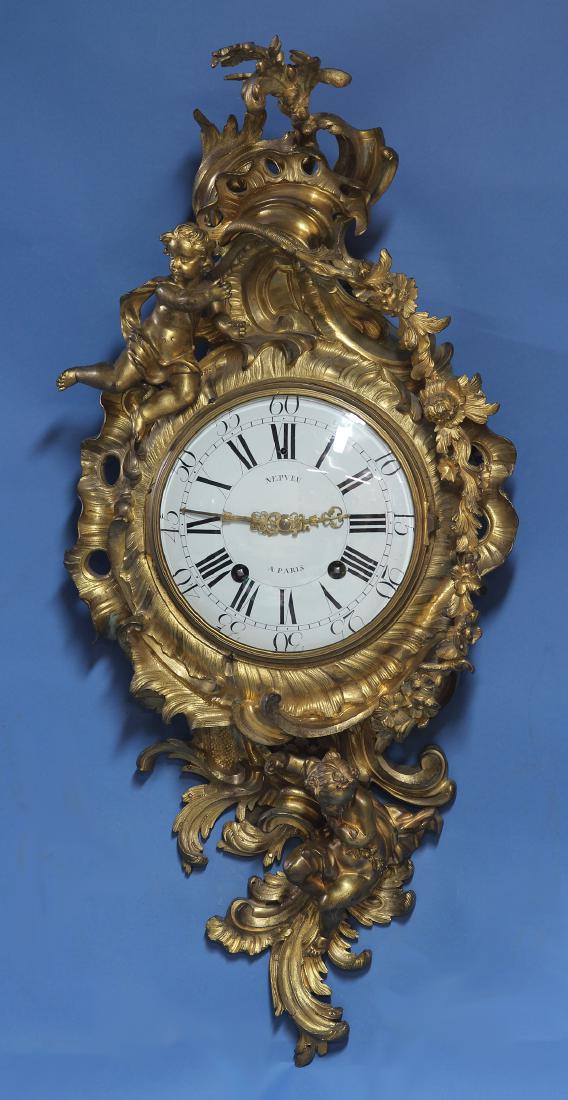 Mid 18th century Ormolu Cartel Clock.: A large Louis XV French ormolu cartel clock by Nepveu Ã Paris. The case has putti, C-scrolls, flower sprays and scrolling foliage. At the sides and front are set engraved floral fabric backed frets