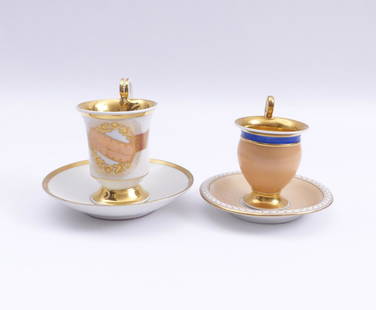 Zwei Biedermeiertassen und Untertassen â€” 19. Jh.: Two Biedermeier Cups and Saucers / â€” 19th century / Cup on foot with purple inscription ''Nimms freundlich an'', rich gold decoration; KPM Berlin, underglaze blue sceptre mark. Egg-shaped cup