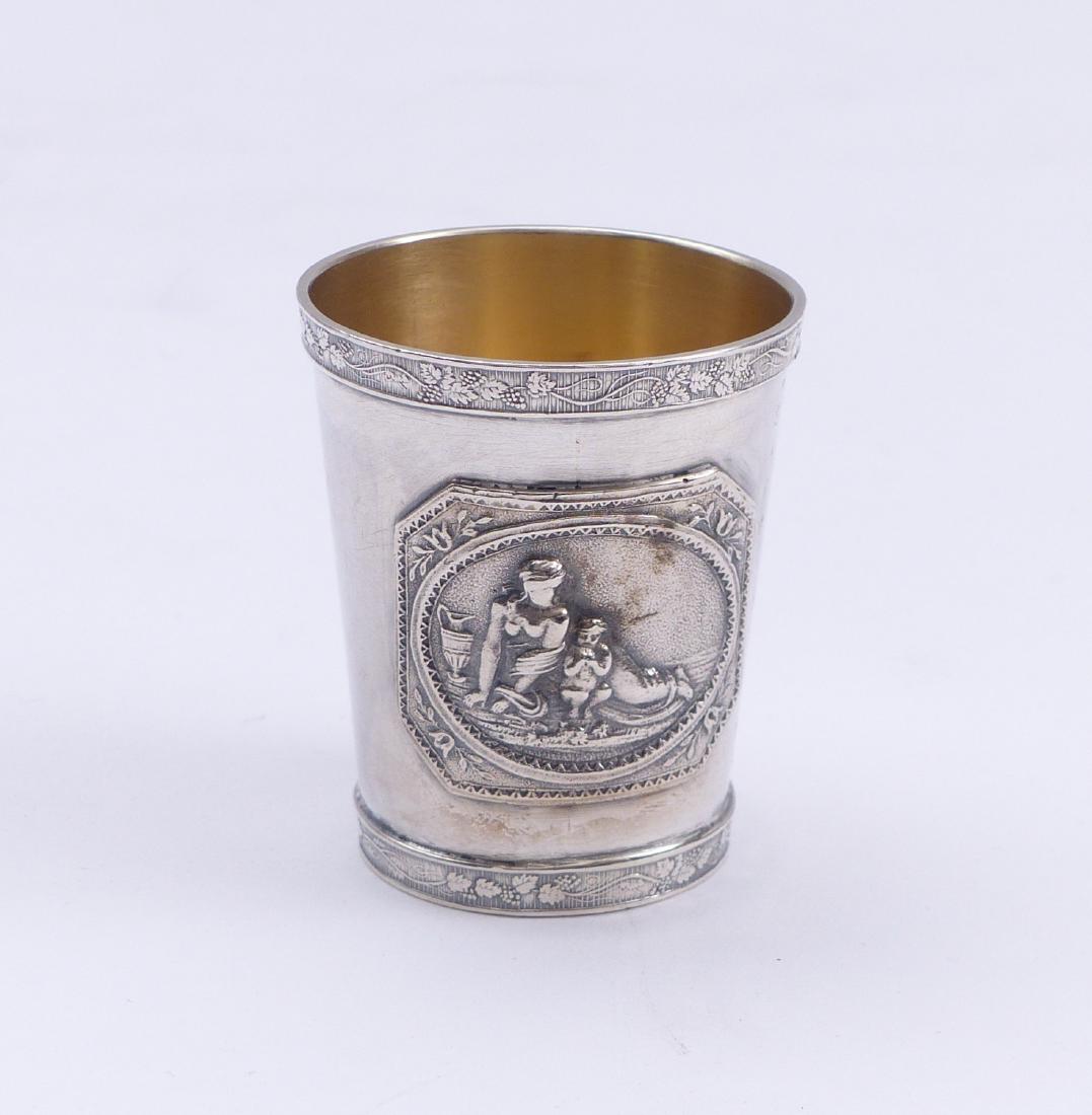 Becher â€” Warschau, E. 19. Jh.: Mug â€” Warsaw, late 19th C. Conical shape with vine leaf bands running around the edges, on the wall two plaques with mythological depictions, probably Venus with cupid. Silver with interior gil