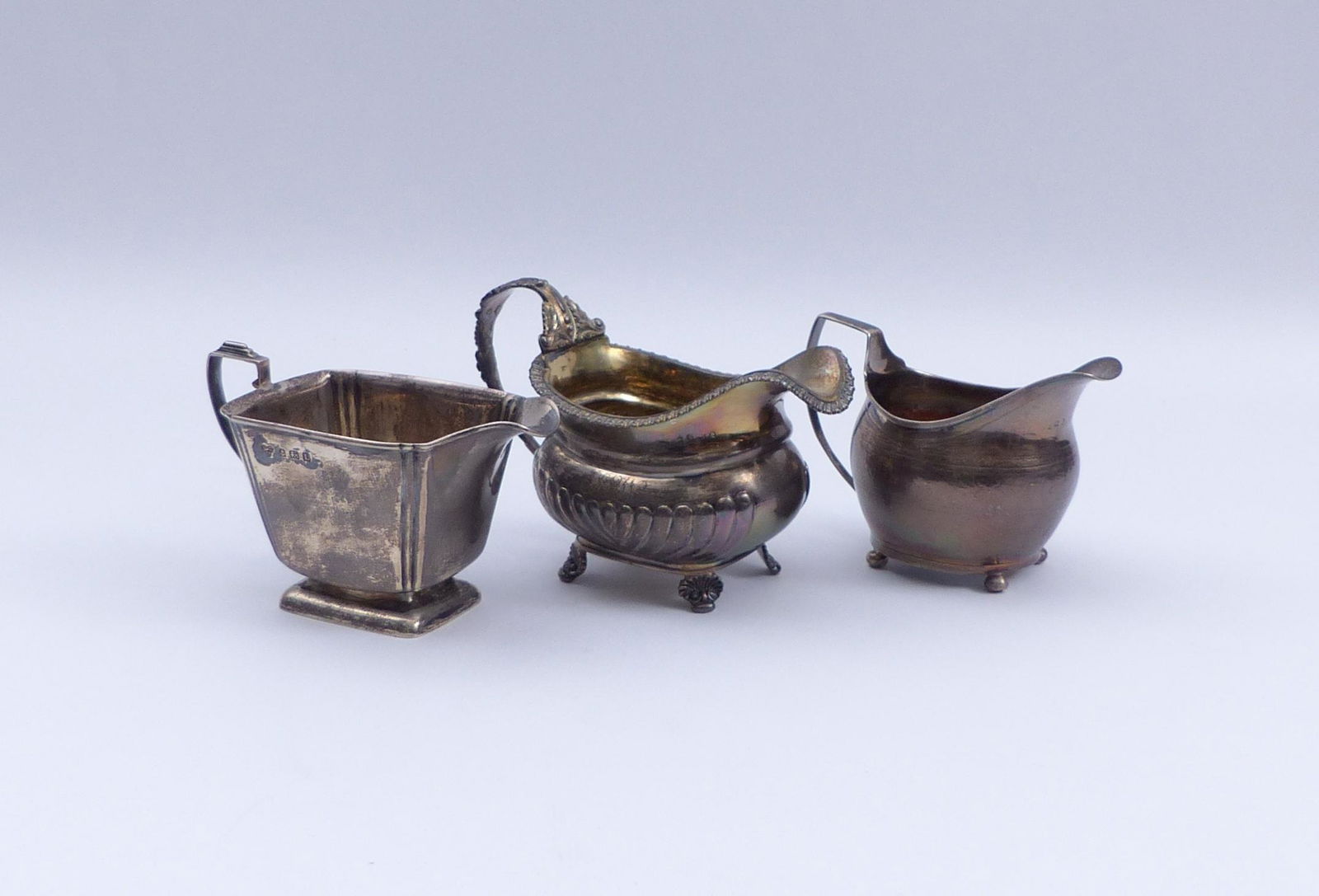 Drei Sahnegiesser, England, 19. und 20. Jh.: Three cream jugs : England, 19th and 20th C. Birmingham, Selfridge & Co Ltd, 1935. London, 1809 (?). London, Thomas Johnson, 1817. Silver. All with hallmarks and master's marks. H. 9 - 10.5 cm; total