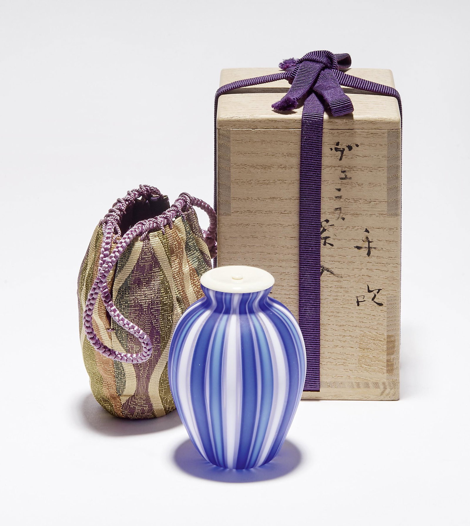 Fujita, Kyohei: Teebehaeltnis (Chaire) in Seidenbeutel (shifuku): Fujita, Kyohei - Tea container (chaire) in silk bag (shifuku). (Tokyo 1921-2004 Chiba) Ovoid with narrowly curving rim. Colourless glass with fine gold powder enamel and vertical bands in white, light