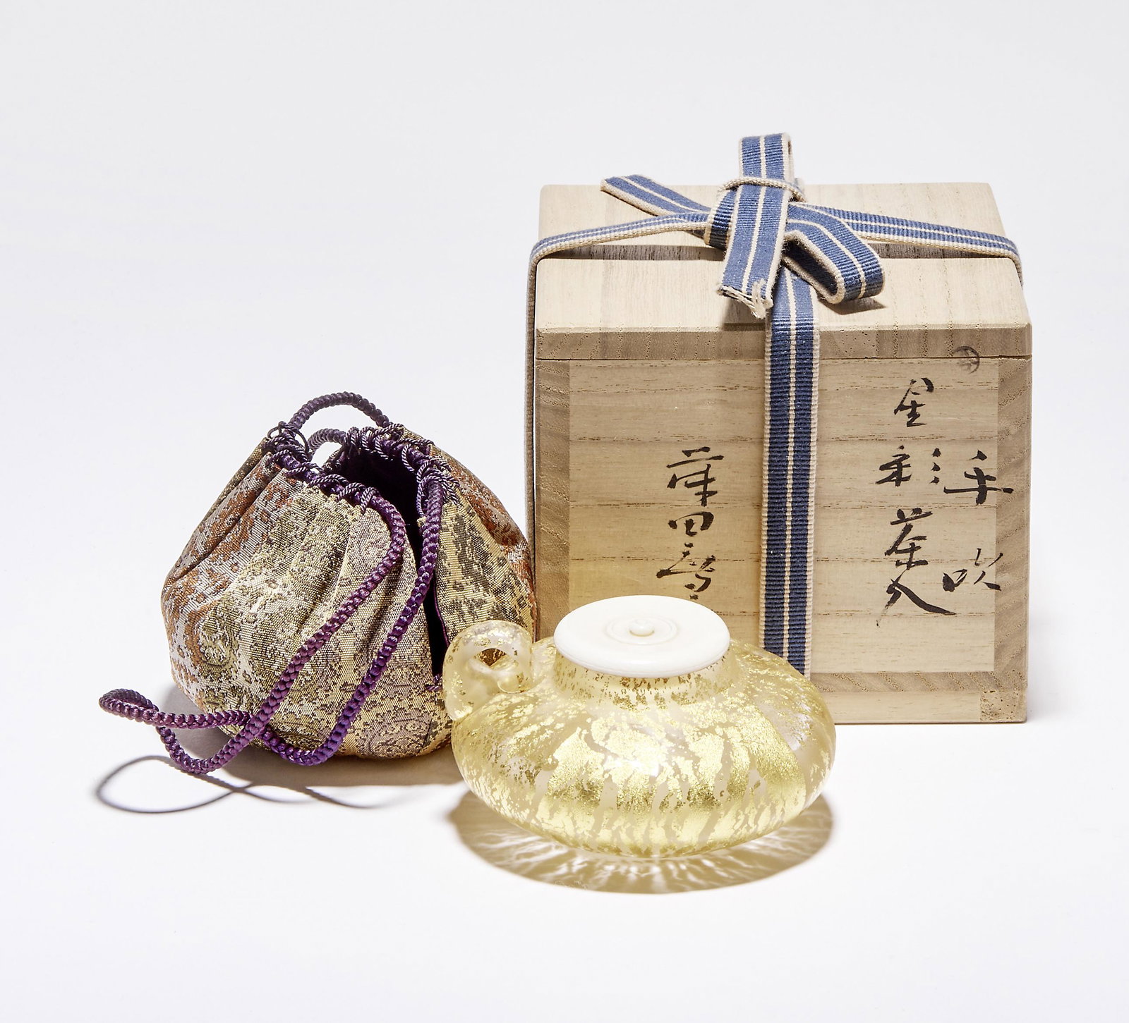 Fujita, Kyohei: Teebehaeltnis (Chaire) in Seidenbeutel (shifuku): Fujita, Kyohei - Tea container (Chaire) in silk bag (shifuku) (Tokyo 1921-2004 Chiba) Depressed bulbous round body with a ring-shaped handle on the shoulder. Colourless glass with almost all-over melt