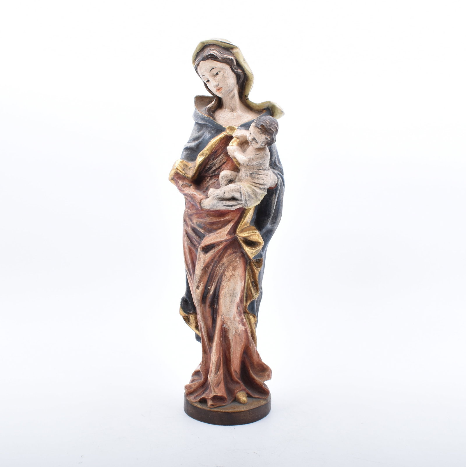 Madonna mit Kind, Tirol, 20. Jh.: Madonna with child - Tyrol, 20th century Standing on a round plinth in a contrapposto, dressed in a red robe with a blue cloak and a veil over her open hair, holding the infant Jesus with both hands.