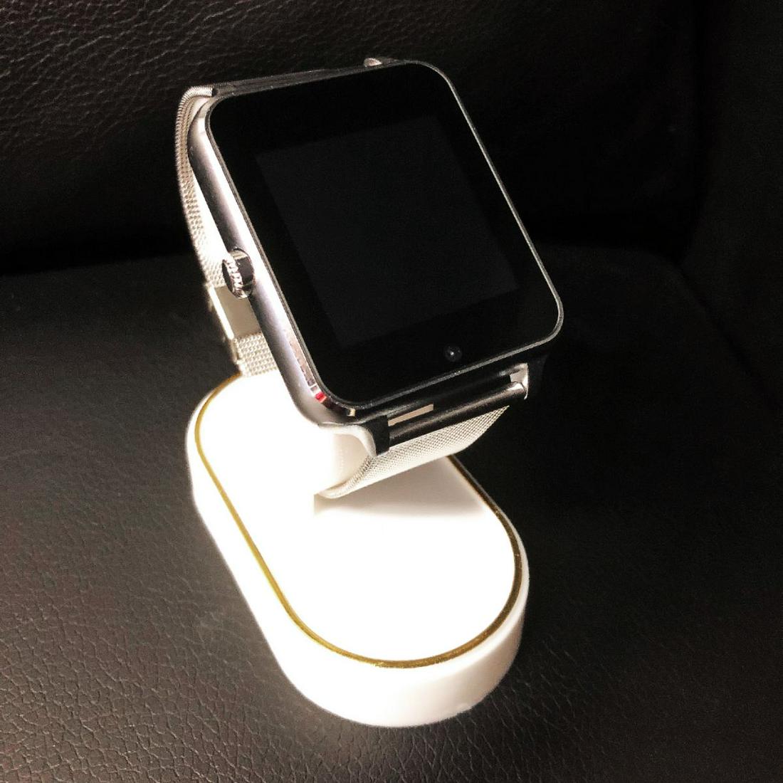 New In Box Silver AI Smart Watch Device With Charger: Brand New AI Watch In Box. Records Step Count, Box Stereo Sound Technology, Blue Tooth, Touch Screen, Mobile Phone Sync, High Definition Display Touch Screen, Remote Capture Option, Sleep Monitoring a