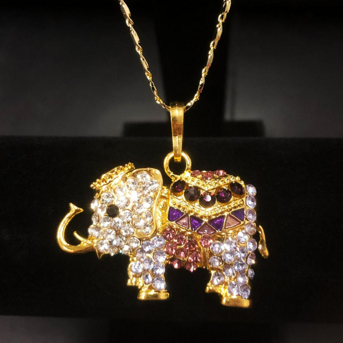 Bejeweled Purple And Gold Rhinestone Ganesh Chaturthi: Bejeweled Purple And Gold Rhinestone Ganesh Chaturthi Elephant Pendant Paired With 18kt Gold Plated Necklace. Comes with a Chinese Window Shade Box. View Photos For Further Details.