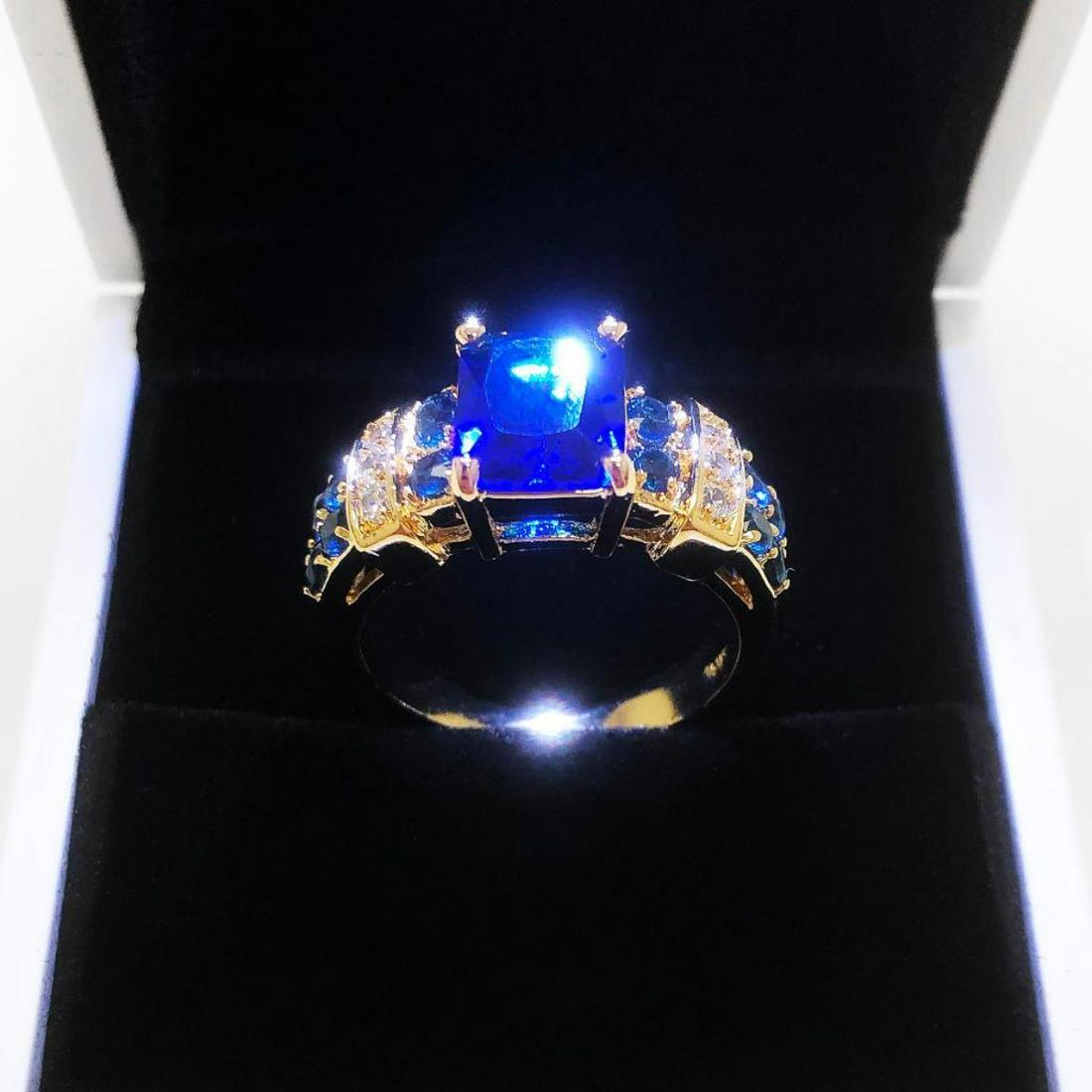 Ladies 6K Tanzanite Stone Ring, Mounted On Gold Tone: Ladies 6K Tanzanite Stone Ring, Mounted On Gold Tone Band With Inset Semi-Precious Stones. Bringing Wisdom, Truth, Dignity And Spiritual Mastery, This Vibrant And Beautiful Ring Is A Great Addition To