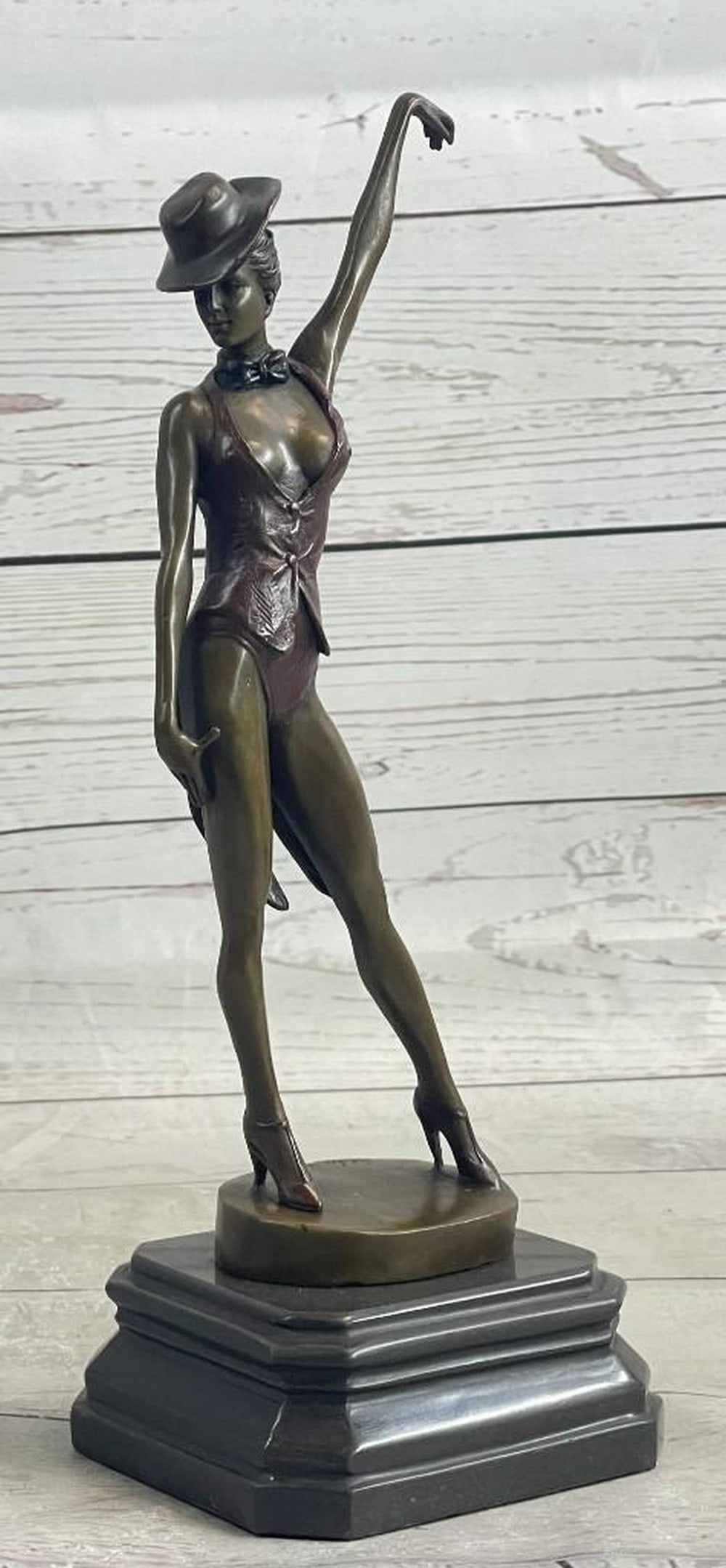 Cabaret Dancer Bronze Sculpture: Cabaret Dancer Bronze Sculpture Cabaret Final Pose. This magnificent dancer struts the final pose of her fierce dance routine, dressed in a short tux with a choker bowtie and a top-hat. She represents