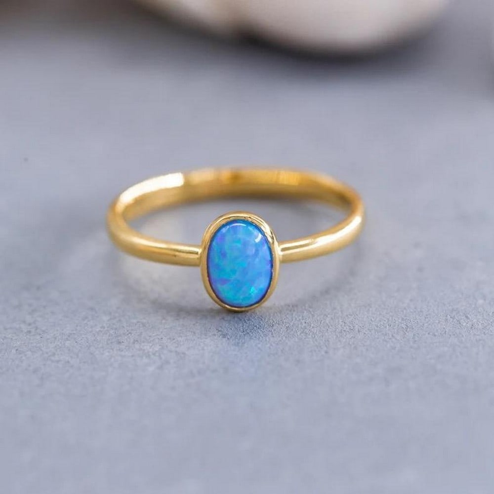 14K Solid Gold Solitaire Ring with Synthetic Opal: 14K Solid Gold Solitaire Ring with Synthetic Opal Elevate your style with our 14K Solid Gold Solitaire Ring featuring a captivating Synthetic Opal. Meticulously crafted, this ring boasts a timeless