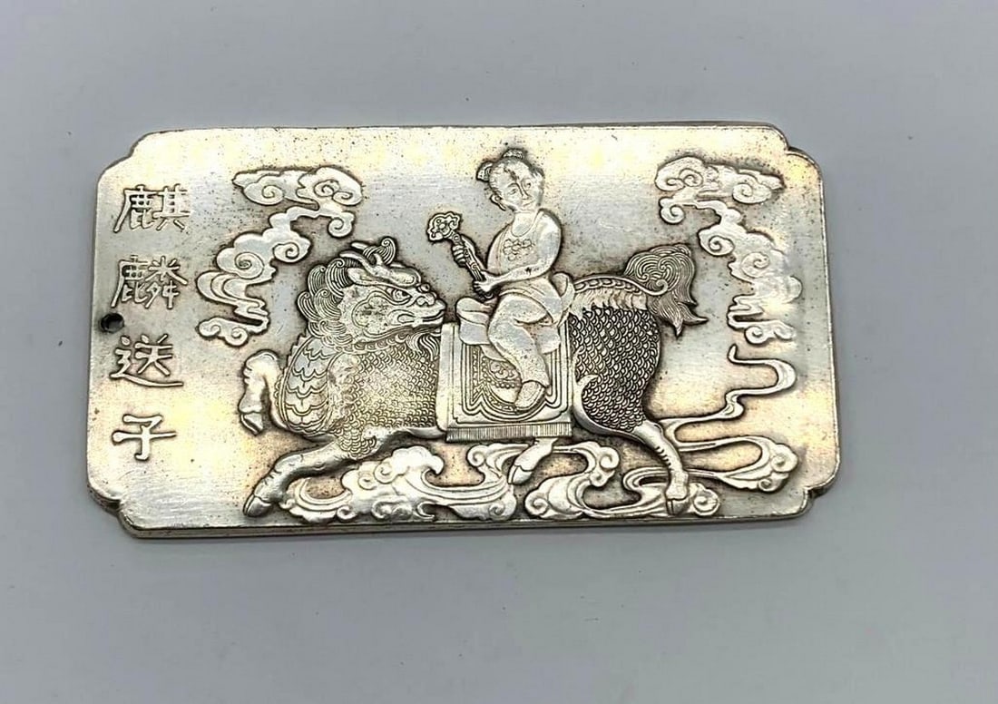Tibetan Silver Bullion Amulet Bar Featuring a Young Person Riding the Kirin: Tibetan silver bullion featuring a young person riding the Kirin. Weighing 136g, 10cm in Length, 5.5cm in Width and 3mm in Thickness. This beautifully crafted piece captures the elegance and power of 