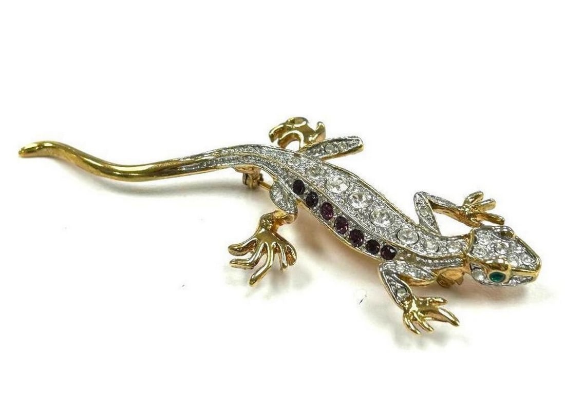 Delicate Gecko Brooch with Encrusted Swarovski Crystals, Purple Amethyst, and Emerald Gemstones: Delicate Gecko Brooch with Encrusted Swarovski Crystals, Purple Amethyst, and Emerald Gemstones Geckos can be identified in many versions of spiritual traditions. These creatures symbolize rebirth, gr