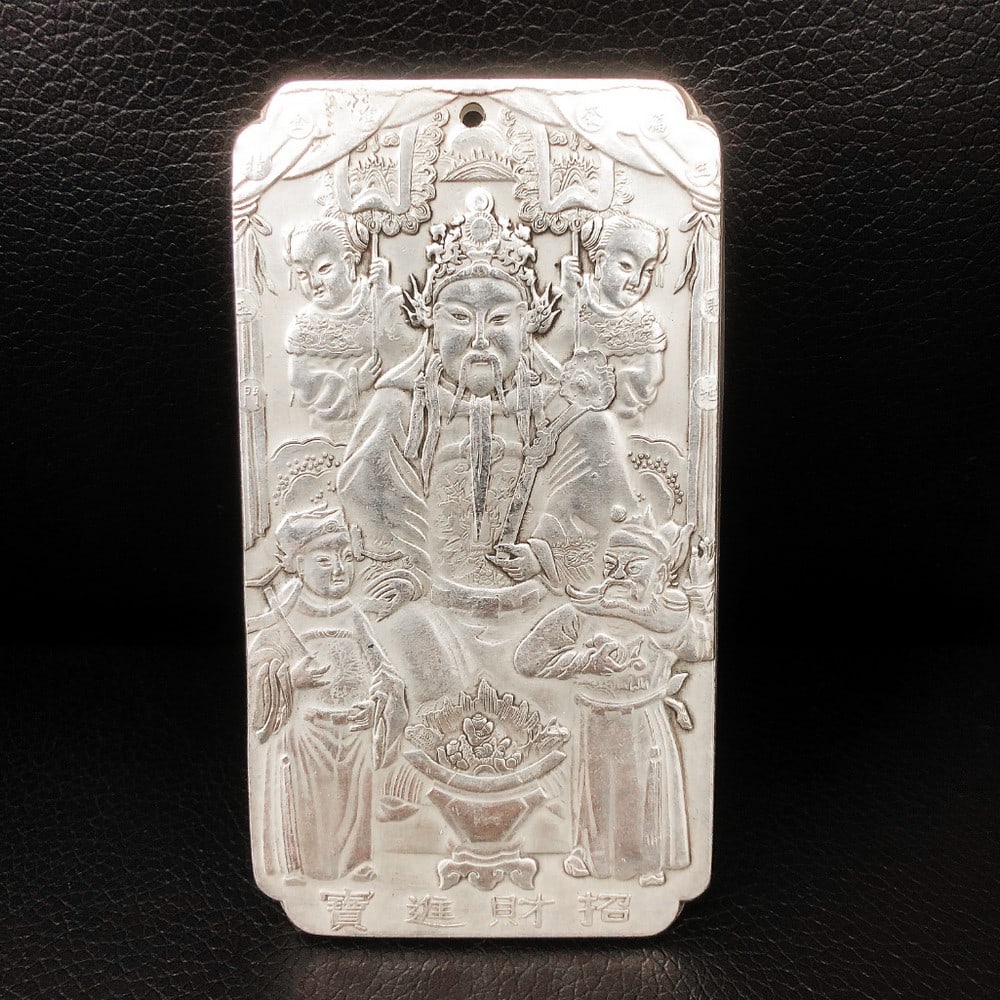 A Tibetan Silver Bullion Depicting The Chinese God Of Wealth, Caishen: A Tibetan Silver Bullion Depicting The Chinese God Of Wealth, Caishen. Weighing 137g, 10cm in Length, 5.5cm in Width, and 3mm in Thickness. This exquisite Tibetan silver bullion features an intricate 
