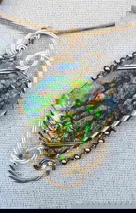 Radiant Stained Glass Ammolite Pendant Necklace: Radiant Stained Glass Ammolite Pendant Necklace This pendant features a freeform ammolite gemstone with no resin coating, displaying vivid orange and green tones with a shimmering effect from natural
