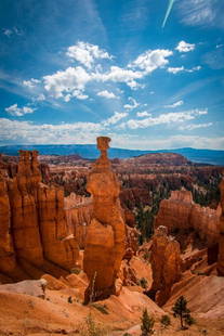 Echoes in Red Rock: Echoes in Red Rock  Bryce Canyon stands as a natural cathedral, with towering hoodoos reaching toward the sky. The sun casts long shadows, painting the red rock formations with a warm glow. The landsc