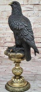 Bronze Eagle on Ornate Gold Patina Base: Bronze Eagle on Ornate Gold Patina Base  This striking bronze sculpture, bearing the signature of artist Milo, features a proud eagle standing tall atop an elegant base reminiscent of a classical bird