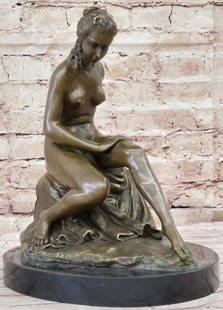Contemplation in Bronze: Nude Woman Sitting on Rock: Contemplation in Bronze: Nude Woman Sitting on Rock  A graceful tribute to classical beauty and introspection, this reproduction bronze statue features a nude female figure seated elegantly on a natur