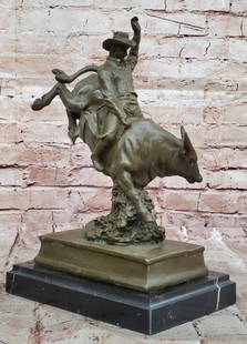 Raging Bull and Cowboy Bronze Sculpture by Remington - 13" x 9": Raging Bull and Cowboy Bronze Sculpture by Remington - 13" x 9" This electrifying bronze sculpture captures the raw power and adrenaline of rodeo life, portraying a cowboy locked in battle wi