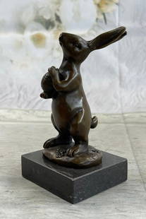 Cuddly Little Bunny Holding a Basket Full of Carrots Bronze Statue: Cuddly Little Bunny Holding a Basket Full of Carrots Bronze Statue.  This cute lil fellow looks up with the sweetest look and holds an egg in his tiny arms. This little rabbit is the perfect touch of