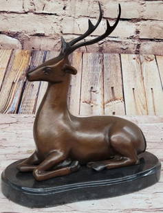 Bronze Reclining Deer Sculpture: Bronze Reclining Deer Sculpture  This elegant bronze sculpture, bearing the signature of artist Milo, captures a reindeer (or caribou, deer, or elk) at rest, yet fully alert. Lying gracefully with its