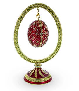 Red Bejeweled Egg Hanging in Display Holder: Red Bejeweled Egg Hanging in Display Holder  This sparkling egg is adorned with clear crystals and high-polished enamel with golden trim. It opens on a hinge and has a magnetic closure to keep the box