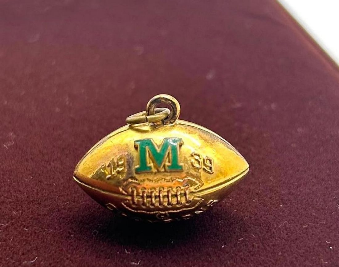 Michigan 1939 Football Champions 1/15 Yellow Gold 10k Charm: 1939 Football Champions 1/15 Yellow Gold 10k Charm This charm is stamped with 1/15 10K Yellow Gold. This charm features a green M, possibly for Michigan. Size: Approximately 1" View Photos For F