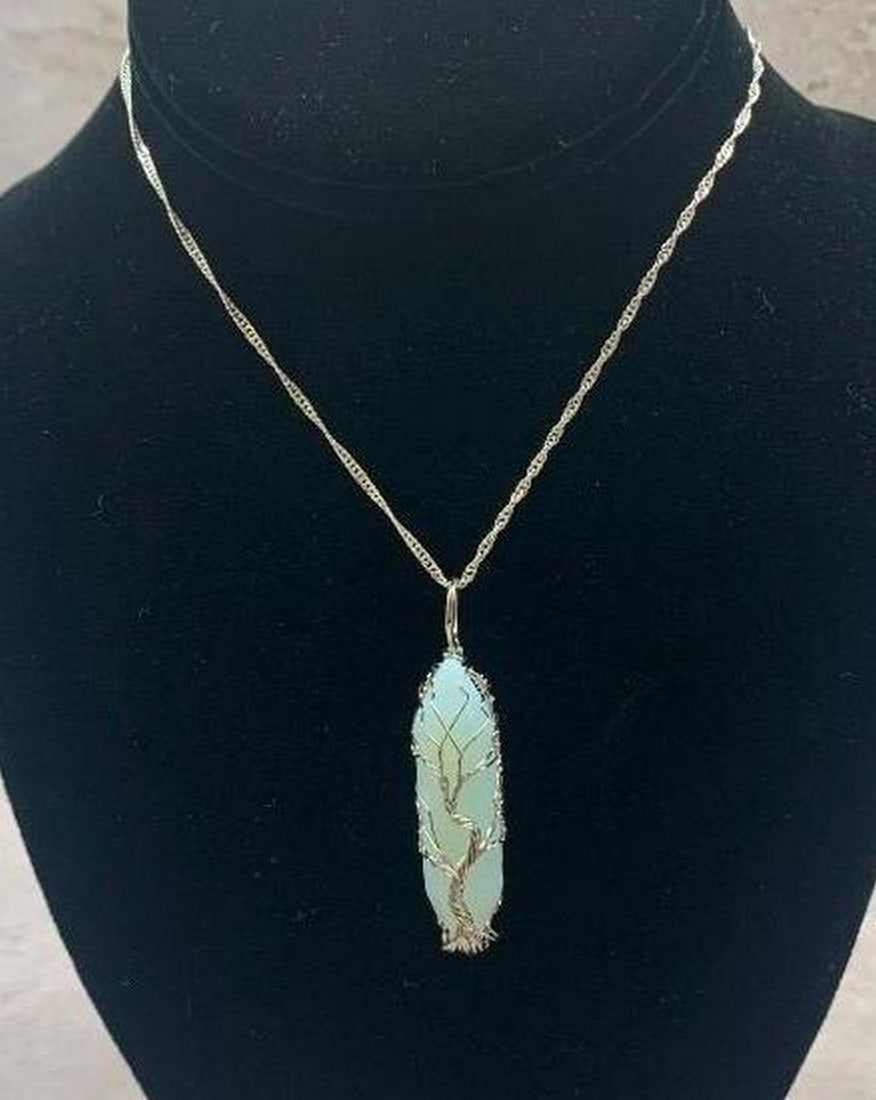 Moonstone Amulet with Silver Tree of Life Wire Design Necklace: Moonstone Amulet with Silver Tree of Life Wire Design Necklace Radiating ethereal beauty and symbolic meaning, this handcrafted moonstone amulet features a stunning silver wire Tree of Life design de